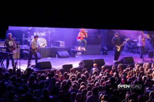 The band The Urge in concert. At a distance with some of the crowd watching them.