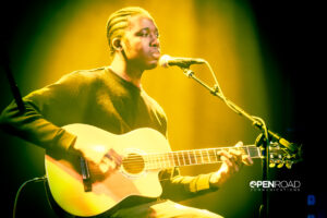 John Roseboro seated, playing guitar