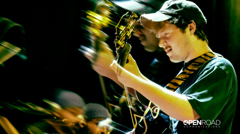 Profile of Brenn! playing guitar is double exposed.
