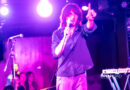 Foxtide's Elijah Gibbins-Croft hold a finger up while singing on stage at their St. Louis concert.
