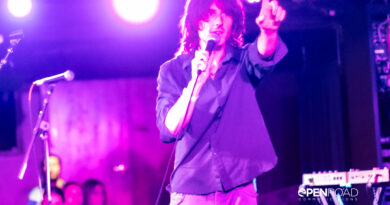 Foxtide's Elijah Gibbins-Croft hold a finger up while singing on stage at their St. Louis concert.