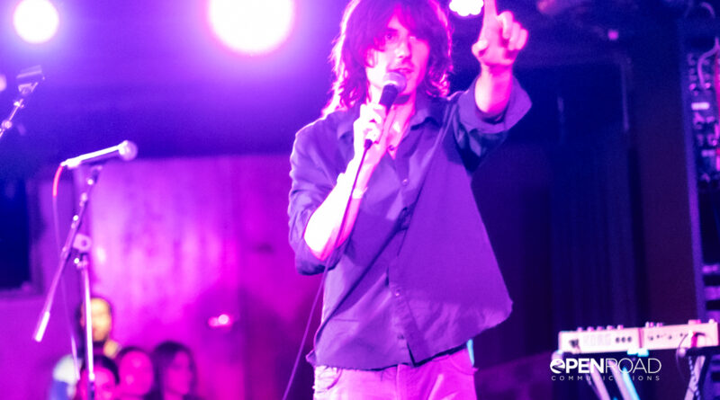 Foxtide's Elijah Gibbins-Croft hold a finger up while singing on stage at their St. Louis concert.