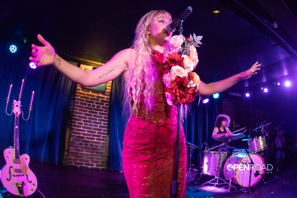 Iluka sings with her arms held out