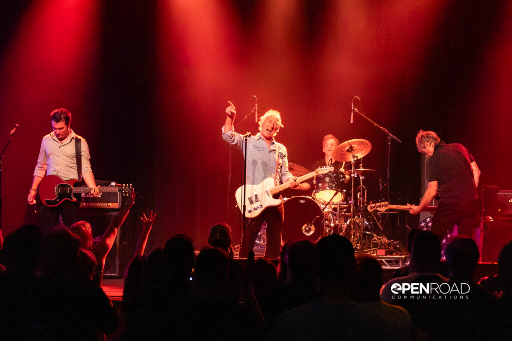 Buzzcocks still got it. Wide image of them all on stage performing.
